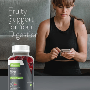 Woman in sportswear holding phone with Jiabei Health prebiotic fiber gummies bottle, promoting fruity digestive support