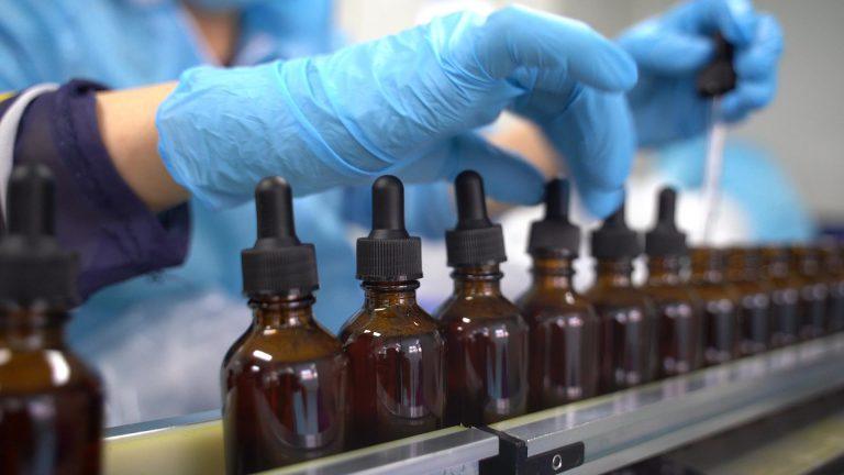 OEM liquid supplement drops manufacturing process with amber dropper bottles on automated production line
