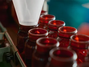 powder supplement filling into bottles on automated production line in GMP certified factory