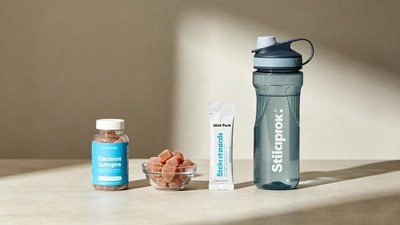 Electrolyte gummies beside a stick pack and sports water bottle