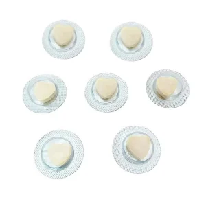 Heart-shaped supplement tablets in individual blister packaging